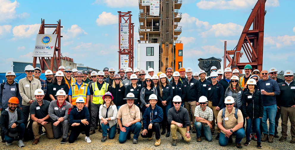 Simpson Strong-Tie employees pose in front of the  NHERI TallWood project, a 10-story wood building, constructed of mass timber.