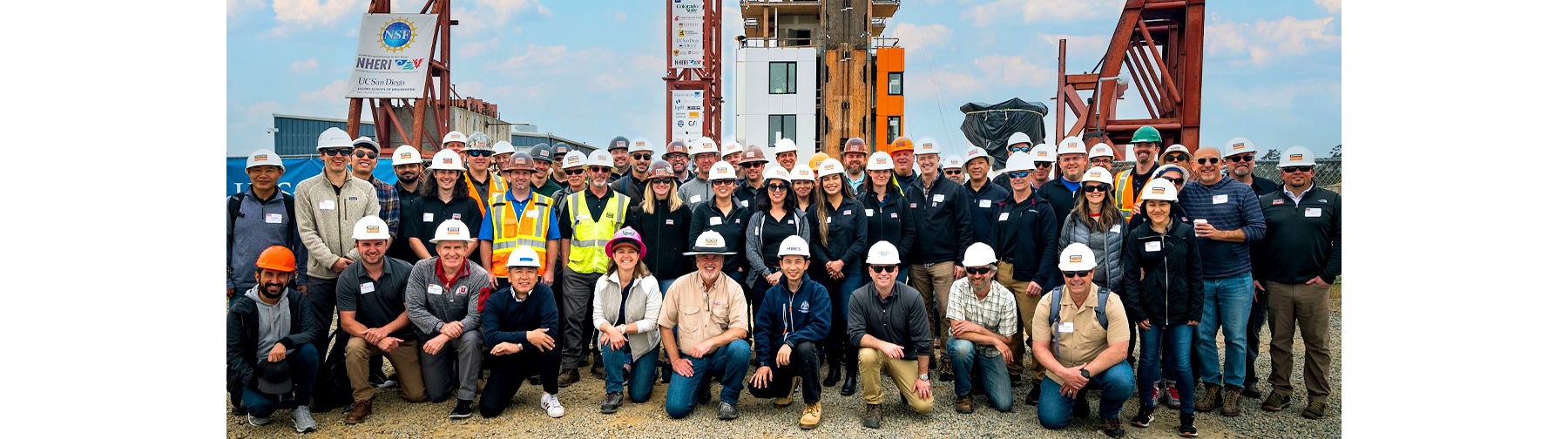 Simpson Strong-Tie employees pose in front of the  NHERI TallWood project, a 10-story wood building, constructed of mass timber.