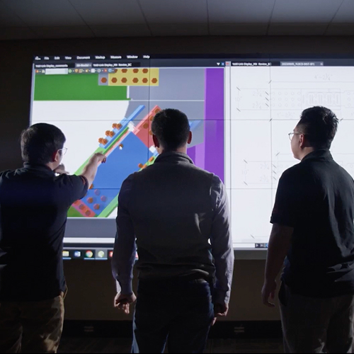 Engineers looking at modeling software on a projected screen.