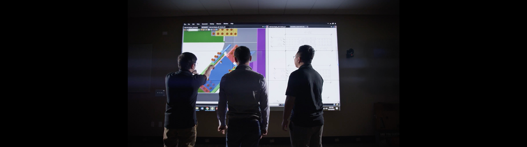 Engineers looking at modeling software on a projected screen.