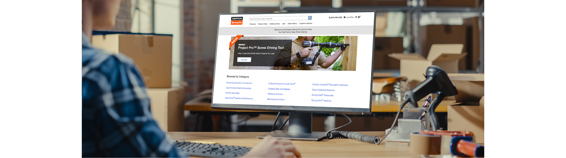 Man sitting at desk viewing computer screen. Computer screen is showing the Customer Portal login page.