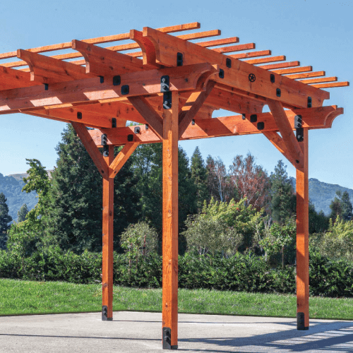 Cedar wood pergola with trees and mountains in the background.