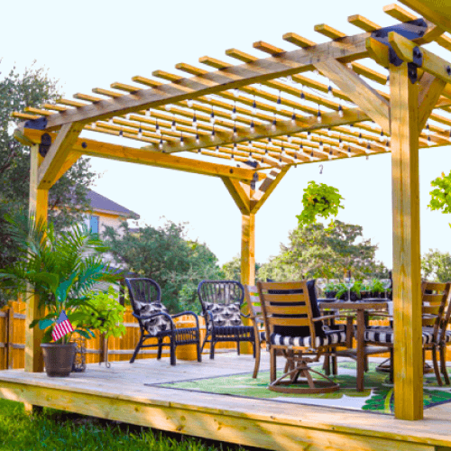 Patio table and chairs under a wood floating deck with a pergola.