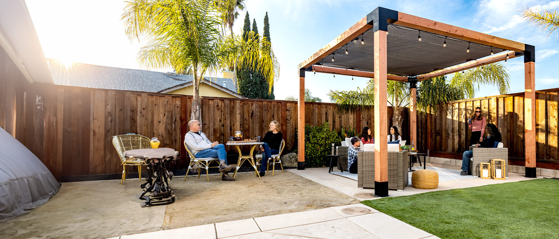 A backyard with a modern pergola built using the Simpson Strong-Tie Sage System, featuring warm lighting and stylish outdoor seating, creating a cozy space for relaxation and social gatherings.