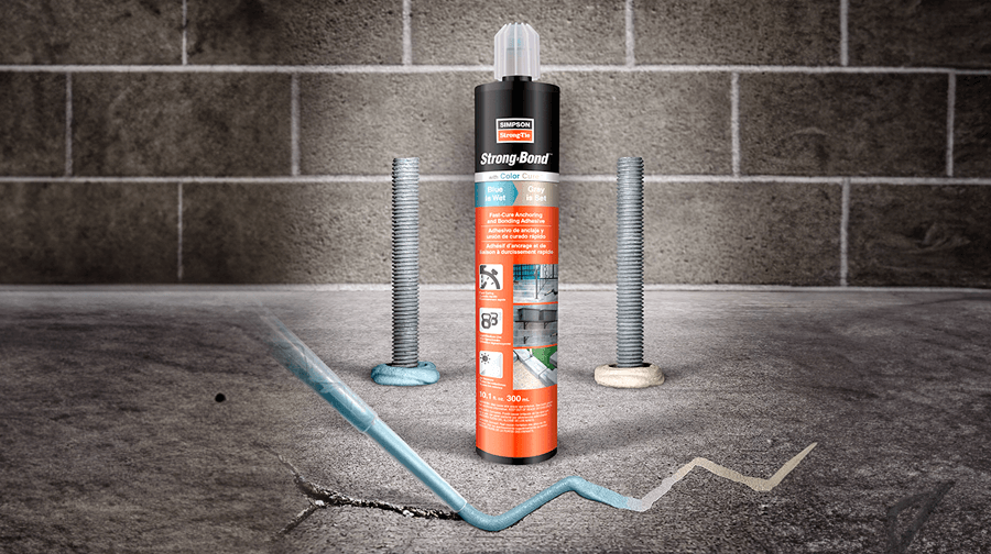 Strong-Bond adhesive tube on cracked concrete with bolts and blue adhesive line; brick wall in background.