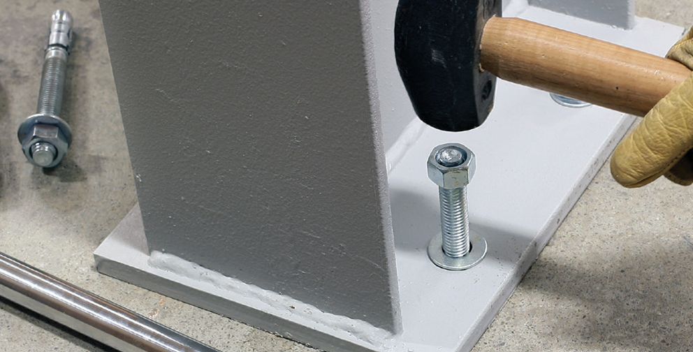 Strong-bolt 2 Wedge Anchor is hammered into metal column and concrete floor.