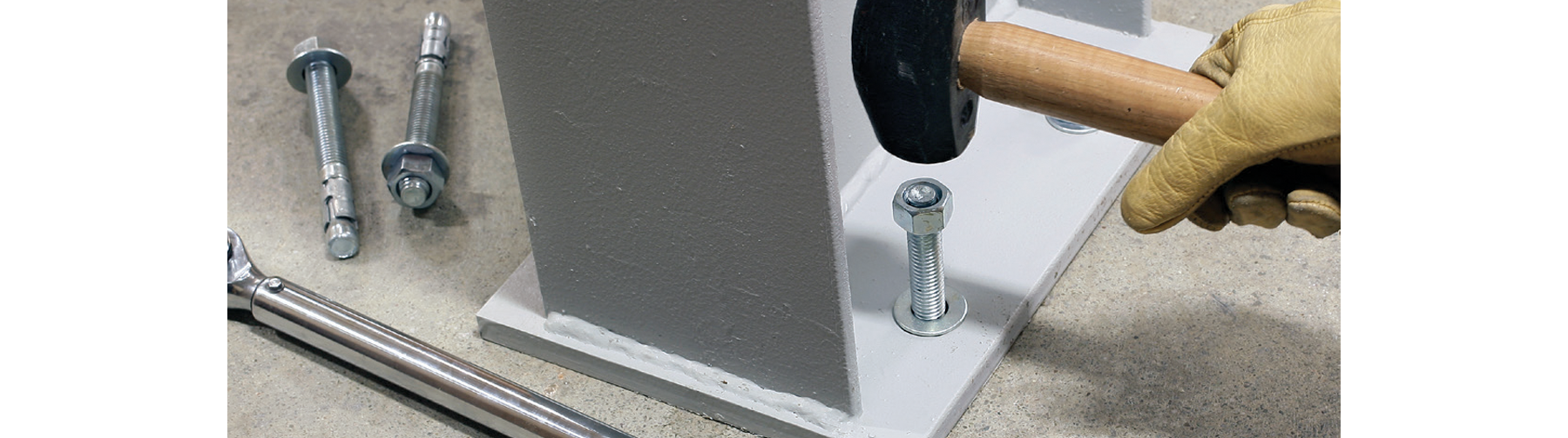 Strong-bolt 2 Wedge Anchor is hammered into metal column and concrete floor.