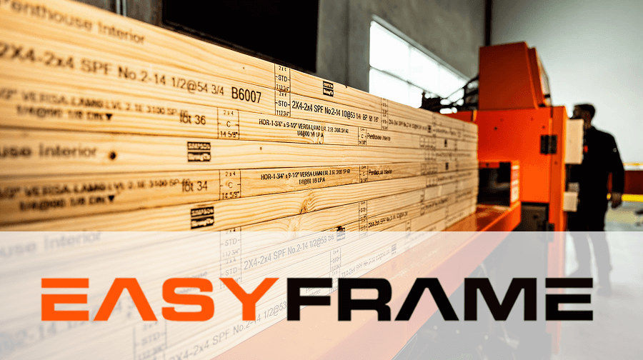 Close-up view of pre-cut engineered lumber labeled “2X4-2X4 SPF” feeding into an orange EasyFrame machine, with a worker blurred in the background. EasyFrame logo is prominently displayed across the bottom.
