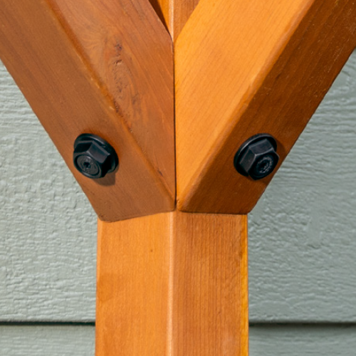 Close-up of structural wood screw and head-hex washer securing wooden beams together.