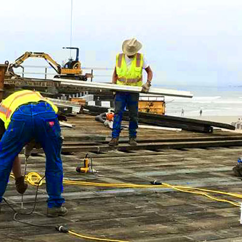 construction workers outside by a beach