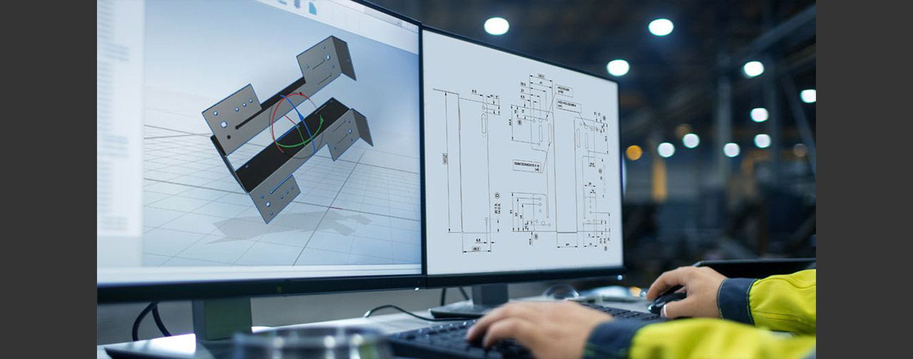 Man typing on keyboard at a desk with two large monitors, one screen displaying a 3d render of a product and other screen is displaying a drawing.