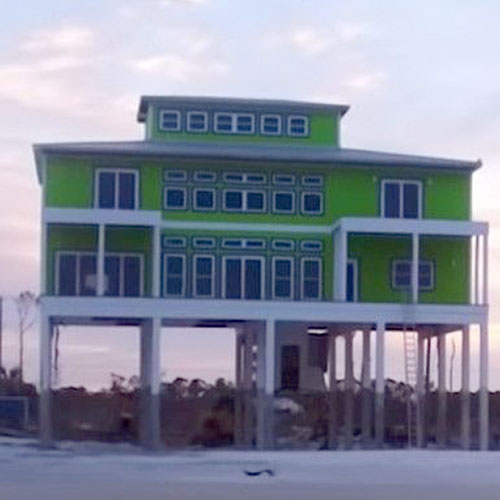 Three story green and white house on stilts