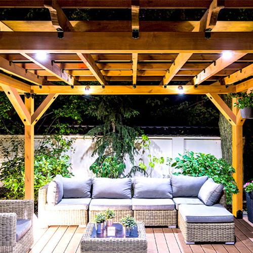 Backyard patio with wooden pergola and wicker furniture set