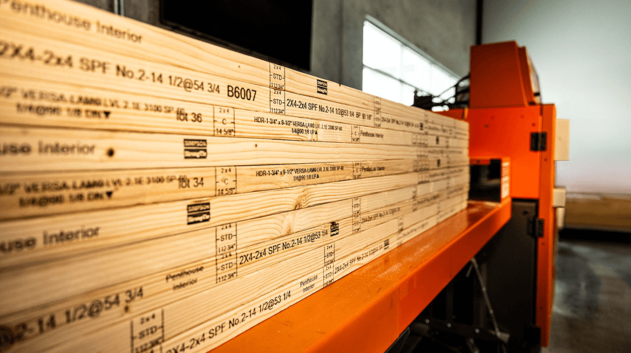 Stacked stamped wooden planks labeled on the EasyFrame equipment in a workshop setting.