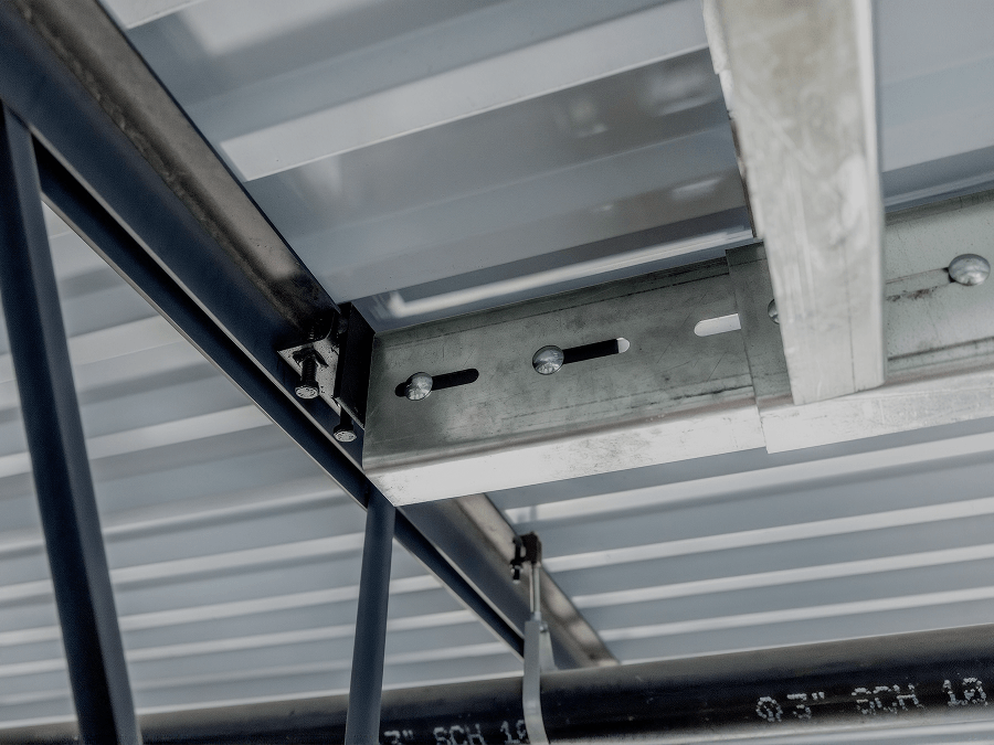 Close-up of a QuickFrames™ structural connection attached to steel framing, showing adjustable components designed for overhead support applications.