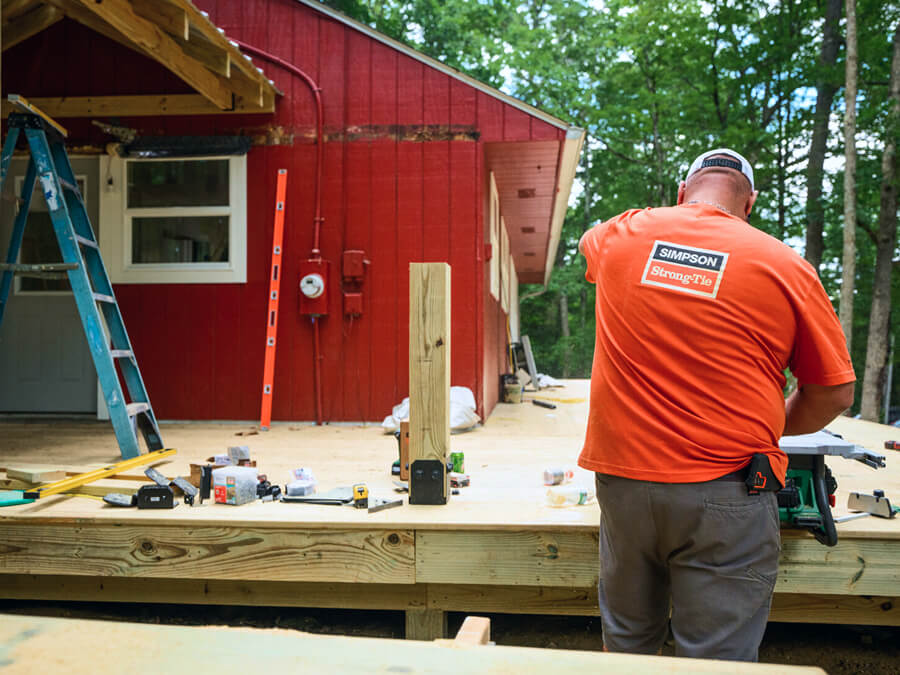 Contractor wearing a Simpson Strong-Tie shirt building an outdoor living structure.